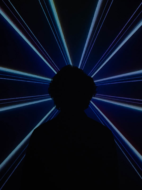 Silhouette of a person with blue lasers in the background