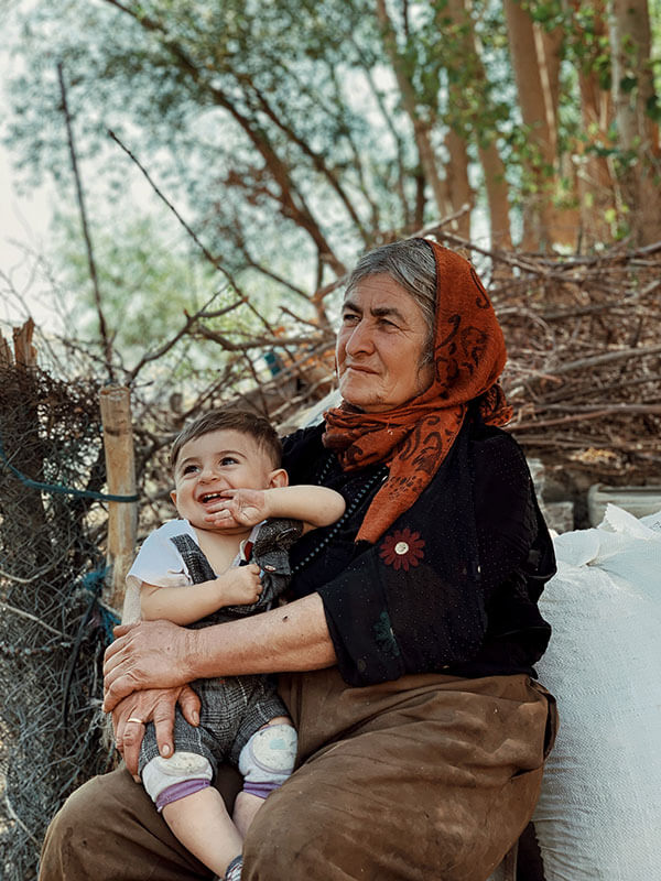 Older woman holding smiling child on lap.