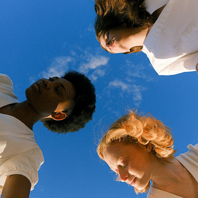 Skyward view of three women's faces