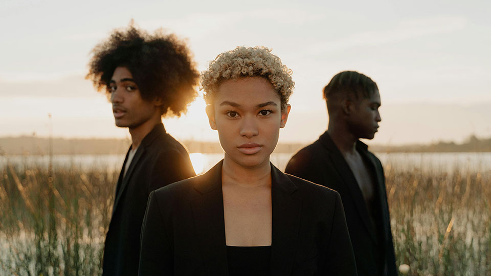 Curly hair woman with men standing behind her